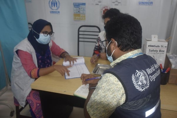 WHO reviews vaccine uptake figures alongside partners at a health facility